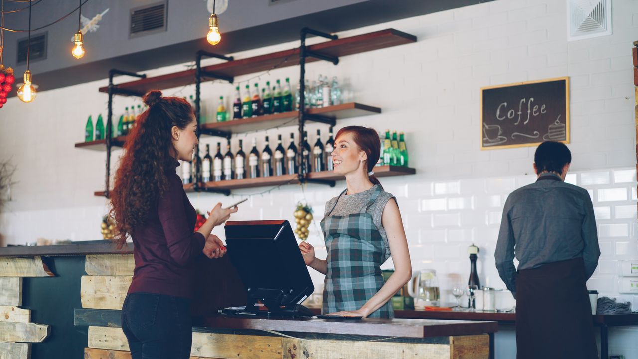 Customer scanning a QR code at a café counter